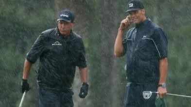 May 24, 2020; Hobe Sound, FL, USA; Phil Mickelson and NFL player Tom Brady of the Tampa Bay Buccaneers react on the 13th green in the rain during The Match: Champions for Charity golf round at the Medalist Golf Club.  Mandatory Credit: Handout Photo by Getty Images for The Match via USA TODAY Sports