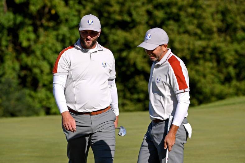 Sep 25, 2021; Haven, Wisconsin, USA; Team Europe player Jon Rahm and Team Europe player Rory McIlroy react on the ninth green during day two four-ball rounds for the 43rd Ryder Cup golf competition at Whistling Straits. Mandatory Credit: Orlando Ramirez-USA TODAY Sports