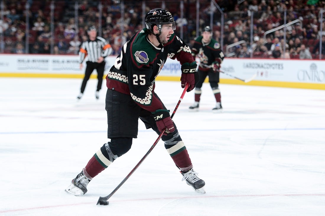 Oct 23, 2021; Glendale, Arizona, USA; Arizona Coyotes defenseman Conor Timmins (25) shoots the puck against the New York Islanders during the second period at Gila River Arena. Mandatory Credit: Joe Camporeale-USA TODAY Sports