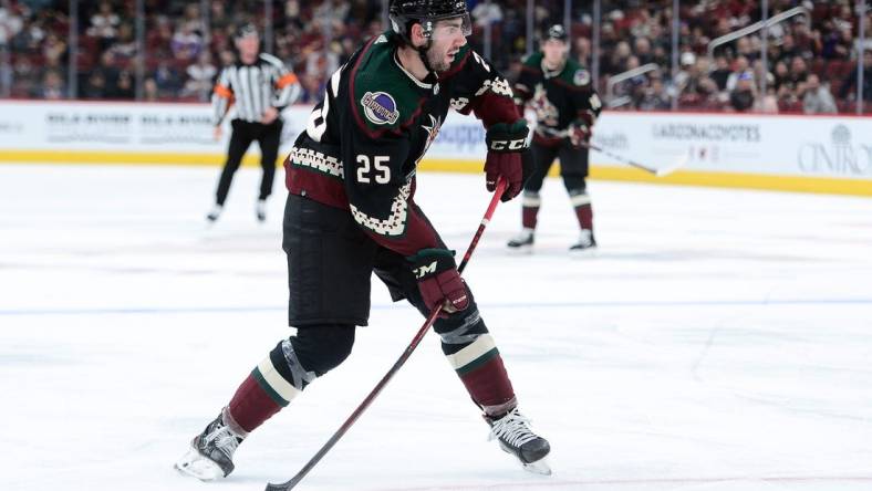 Oct 23, 2021; Glendale, Arizona, USA; Arizona Coyotes defenseman Conor Timmins (25) shoots the puck against the New York Islanders during the second period at Gila River Arena. Mandatory Credit: Joe Camporeale-USA TODAY Sports