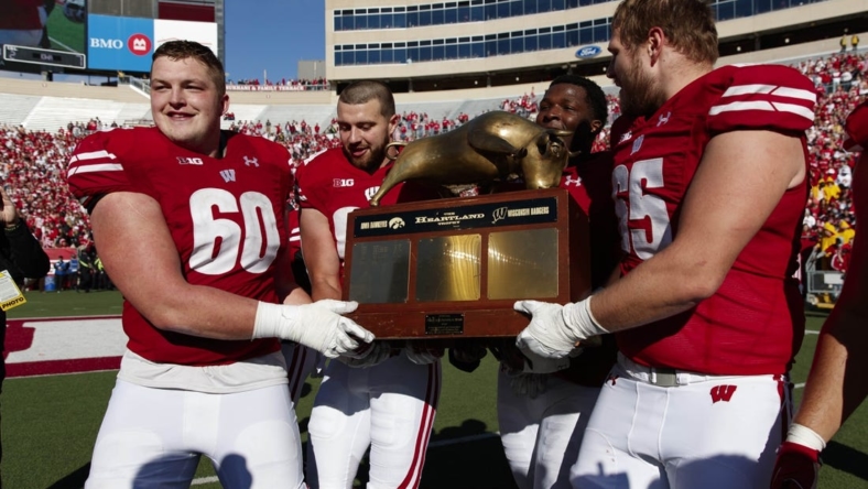 Oct 30, 2021; Madison, Wisconsin, USA; Wisconsin Badgers players celebrate with the Heartland Trophy following the game against the Iowa Hawkeyes at Camp Randall Stadium. Mandatory Credit: Jeff Hanisch-USA TODAY Sports