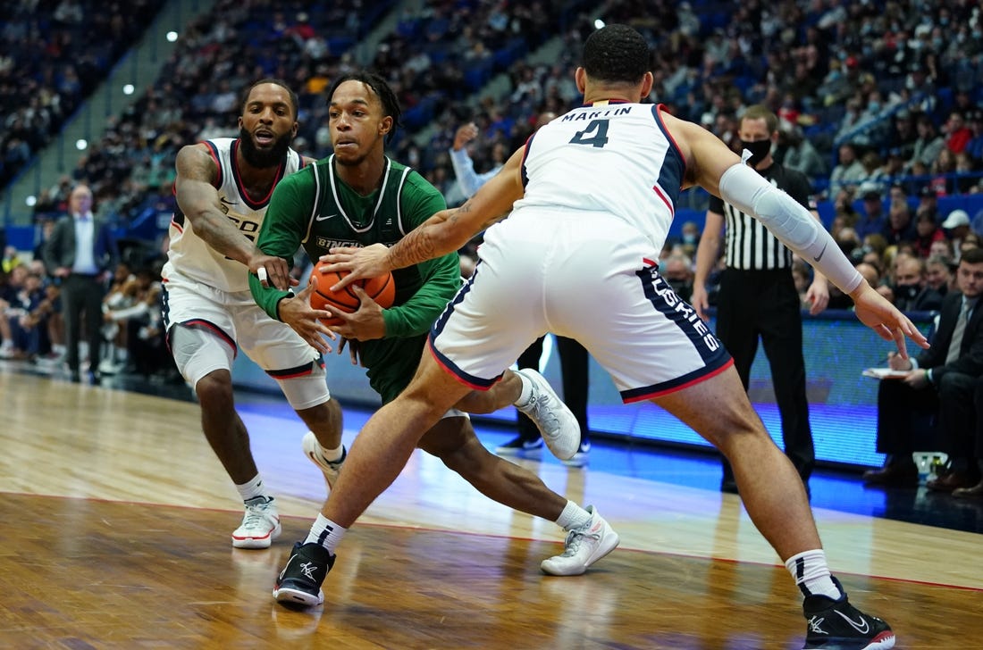 Nov 20, 2021; Hartford, Connecticut, USA; Binghamton Bearcats guard Johnathan McGriff (0) drives the ball against Connecticut Huskies guard Tyrese Martin (4) and guard R.J. Cole (2) in the second half at XL Center. Mandatory Credit: David Butler II-USA TODAY Sports