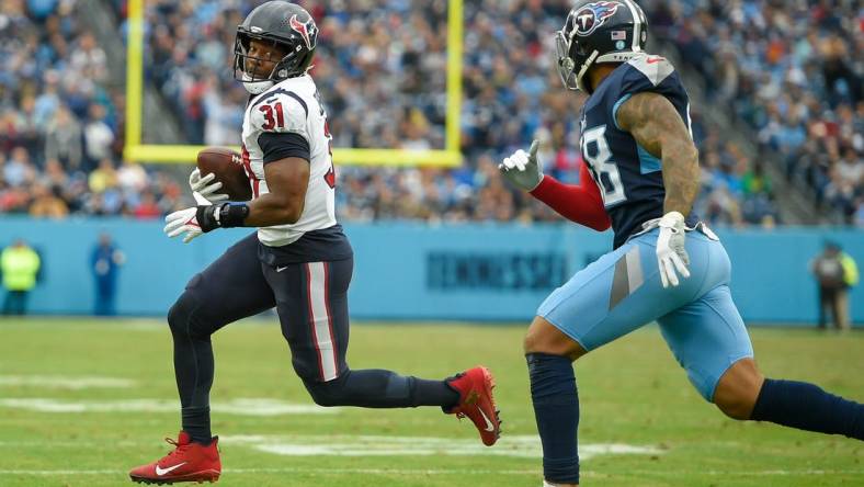 Nov 21, 2021; Nashville, Tennessee, USA;  Houston Texans running back David Johnson (31) runs as Tennessee Titans linebacker Harold Landry (58) gives chase during the second half at Nissan Stadium. Mandatory Credit: Steve Roberts-USA TODAY Sports