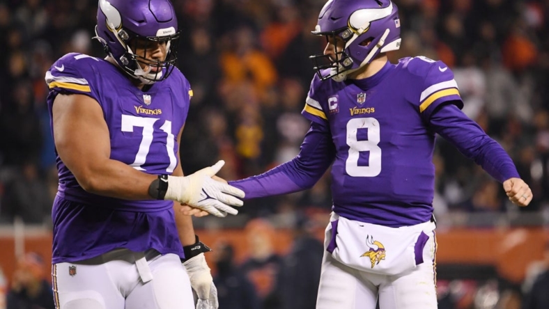 Dec 20, 2021; Chicago, Illinois, USA; Minnesota Vikings quarterback Kirk Cousins (8) and Minnesota Vikings offensive tackle Christian Darrisaw (71) celebrate after the touchdown in the second half against the Chicago Bears at Soldier Field. Mandatory Credit: Quinn Harris-USA TODAY Sports