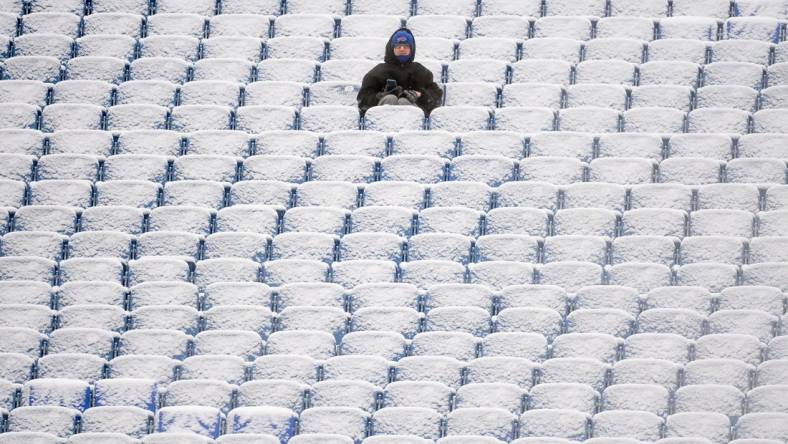 Jan 2, 2022; Orchard Park, New York, USA; A fan sits in the snow covered stands prior to the game between the Atlanta Falcons and the Buffalo Bills at Highmark Stadium. Mandatory Credit: Rich Barnes-USA TODAY Sports