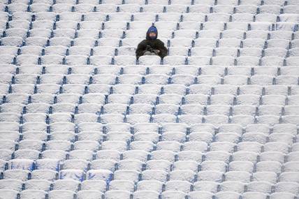Jan 2, 2022; Orchard Park, New York, USA; A fan sits in the snow covered stands prior to the game between the Atlanta Falcons and the Buffalo Bills at Highmark Stadium. Mandatory Credit: Rich Barnes-USA TODAY Sports