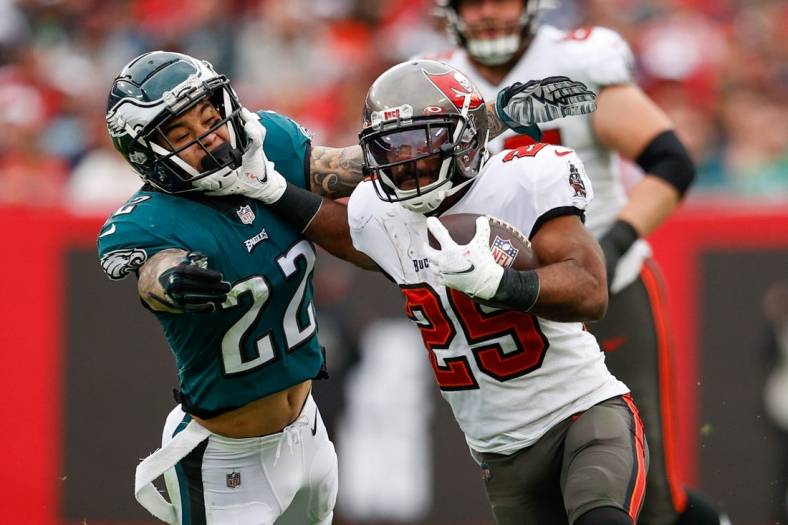 Jan 16, 2022; Tampa, Florida, USA; Tampa Bay Buccaneers running back Giovani Bernard (25) holds off Philadelphia Eagles free safety Marcus Epps (22) in the third quarter in a NFC Wild Card playoff football game at Raymond James Stadium. Mandatory Credit: Nathan Ray Seebeck-USA TODAY Sports