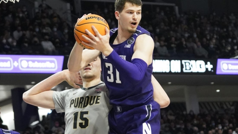 Feb 16, 2022; Evanston, Illinois, USA; Northwestern Wildcats forward Robbie Beran (31) grabs a rebound in front of Purdue Boilermakers center Zach Edey (15) during the first half at Welsh-Ryan Arena. Mandatory Credit: David Banks-USA TODAY Sports