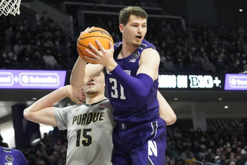 Feb 16, 2022; Evanston, Illinois, USA; Northwestern Wildcats forward Robbie Beran (31) grabs a rebound in front of Purdue Boilermakers center Zach Edey (15) during the first half at Welsh-Ryan Arena. Mandatory Credit: David Banks-USA TODAY Sports