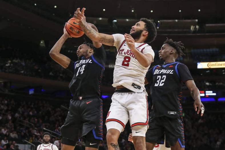 Mar 9, 2022; New York, NY, USA;  DePaul Blue Demons center Nick Ongenda (14) and St. John's Red Storm guard Julian Champagnie (2) fight for a loose ball in the second half at the Big East Conference Tournament at Madison Square Garden. Mandatory Credit: Wendell Cruz-USA TODAY Sports