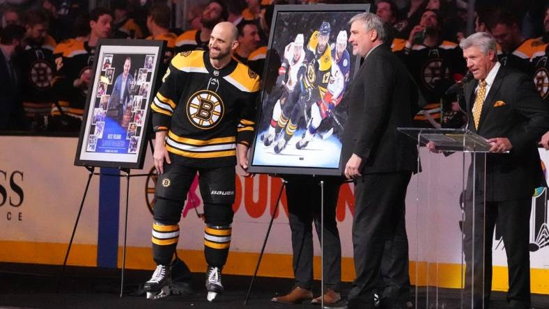 Apr 2, 2022; Boston, Massachusetts, USA; Boston Bruins president Cam Neely presents Boston Bruins left wing Nick Foligno (17) with a painting depicting his career to commemorate him playing in 1000 games prior to the game against the Columbus Blue Jackets at TD Garden. Mandatory Credit: Gregory Fisher-USA TODAY Sports