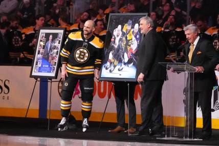 Apr 2, 2022; Boston, Massachusetts, USA; Boston Bruins president Cam Neely presents Boston Bruins left wing Nick Foligno (17) with a painting depicting his career to commemorate him playing in 1000 games prior to the game against the Columbus Blue Jackets at TD Garden. Mandatory Credit: Gregory Fisher-USA TODAY Sports