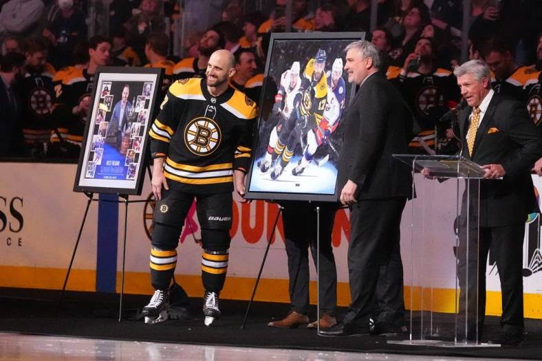 Apr 2, 2022; Boston, Massachusetts, USA; Boston Bruins president Cam Neely presents Boston Bruins left wing Nick Foligno (17) with a painting depicting his career to commemorate him playing in 1000 games prior to the game against the Columbus Blue Jackets at TD Garden. Mandatory Credit: Gregory Fisher-USA TODAY Sports
