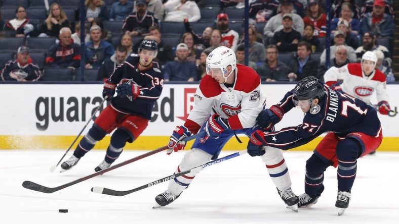 Apr 13, 2022; Columbus, Ohio, USA; Columbus Blue Jackets defenseman Nick Blankenburg (77) sticks the puck away from Montreal Canadiens right wing Tyler Pitlick (24) during the third period at Nationwide Arena. Mandatory Credit: Russell LaBounty-USA TODAY Sports