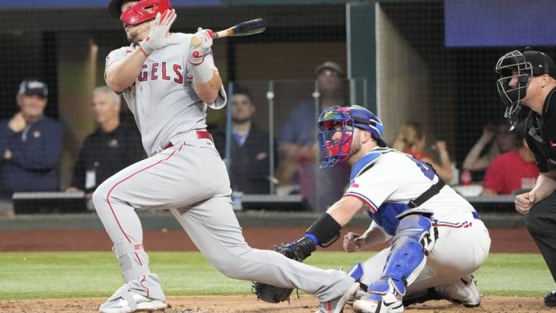 Apr 15, 2022; Arlington, Texas, USA; Los Angeles Angels center fielder Mike Trout follows through on his swing for an infield hit against the Texas Rangers during the third inning of a baseball game at Globe Life Field. Mandatory Credit: Jim Cowsert-USA TODAY Sports