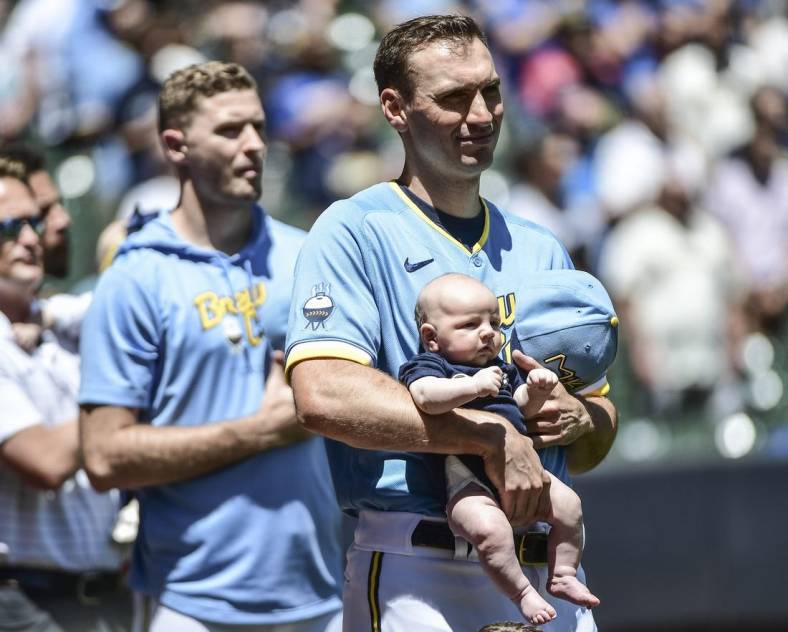 Jun 26, 2022; Milwaukee, Wisconsin, USA; Milwaukee Brewers pitcher Brent Suter (35) holds his baby during the National Anthem before game against Toronto Blue Jays at American Family Field. Mandatory Credit: Benny Sieu-USA TODAY Sports