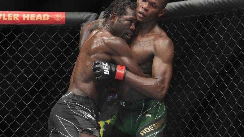 Jul 2, 2022; Las Vegas, Nevada, USA; Israel Adesanya (red gloves) and Jared Cannonier (blue gloves) fight in a bout during UFC 276 at T-Mobile Arena. Mandatory Credit: Stephen R. Sylvanie-USA TODAY Sports