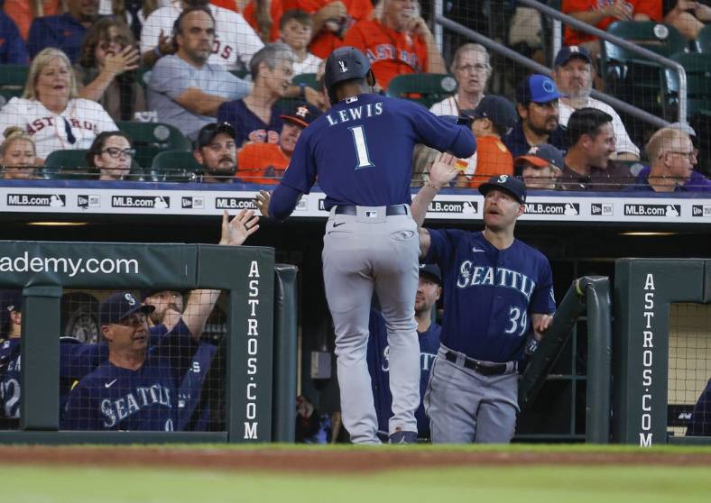 Jul 30, 2022; Houston, Texas, USA; Seattle Mariners designated hitter Kyle Lewis (1) celebrates in the dugout after scoring a run during the first inning against the Houston Astros at Minute Maid Park. Mandatory Credit: Troy Taormina-USA TODAY Sports