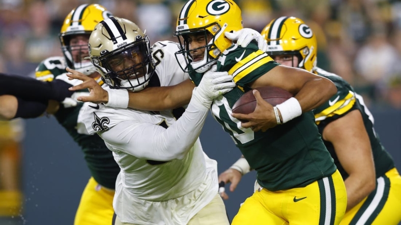 Aug 19, 2022; Green Bay, Wisconsin, USA;  Green Bay Packers quarterback Jordan Love (10) is tackled by New Orleans Saints defensive end Taco Charlton (54) during the second quarter at Lambeau Field. Mandatory Credit: Jeff Hanisch-USA TODAY Sports