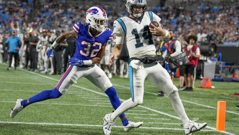 Aug 26, 2022; Charlotte, North Carolina, USA; Carolina Panthers quarterback Sam Darnold (14) scores a touchdown while defended by Buffalo Bills cornerback Jordan Miller (32) during the second half at Bank of America Stadium. Mandatory Credit: Jim Dedmon-USA TODAY Sports