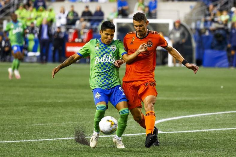 Sep 4, 2022; Seattle, Washington, USA; Houston Dynamo defender Daniel Steres (2) clears a ball in the box away from Seattle Sounders FC forward Raul Ruidiaz (9) during the second half at Lumen Field. Mandatory Credit: Joe Nicholson-USA TODAY Sports