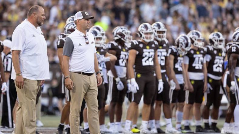 Sep 17, 2022; Kalamazoo, Michigan, USA; Western Michigan Broncos head coach Tim Lester (middle) and defensive coordinator Lou Esposito (left) watch pregame warm ups against Pittsburgh Panthers at Waldo Stadium. Mandatory Credit: Kimberly Moss-USA TODAY Sports