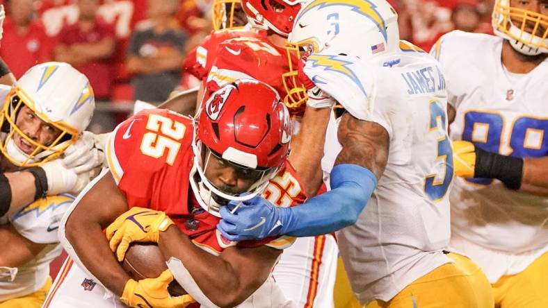 Sep 15, 2022; Kansas City, Missouri, USA; Kansas City Chiefs running back Clyde Edwards-Helaire (25) runs the ball as Los Angeles Chargers safety Derwin James Jr. (3) attempts the tackle during the game at GEHA Field at Arrowhead Stadium. Mandatory Credit: Denny Medley-USA TODAY Sports