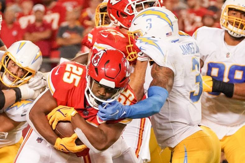 Sep 15, 2022; Kansas City, Missouri, USA; Kansas City Chiefs running back Clyde Edwards-Helaire (25) runs the ball as Los Angeles Chargers safety Derwin James Jr. (3) attempts the tackle during the game at GEHA Field at Arrowhead Stadium. Mandatory Credit: Denny Medley-USA TODAY Sports