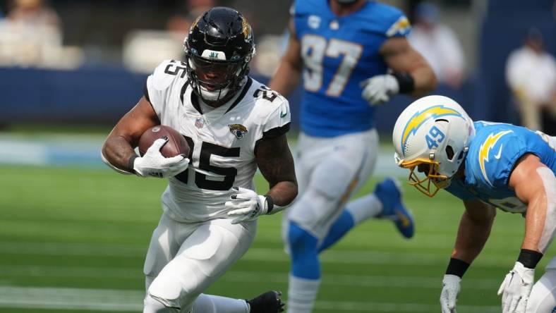 Sep 25, 2022; Inglewood, California, USA; Jacksonville Jaguars running back James Robinson (25)
 is tackled by Los Angeles Chargers linebacker Drue Tranquill (49) in the first half at SoFi Stadium. Mandatory Credit: Kirby Lee-USA TODAY Sports