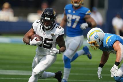 Sep 25, 2022; Inglewood, California, USA; Jacksonville Jaguars running back James Robinson (25)
 is tackled by Los Angeles Chargers linebacker Drue Tranquill (49) in the first half at SoFi Stadium. Mandatory Credit: Kirby Lee-USA TODAY Sports