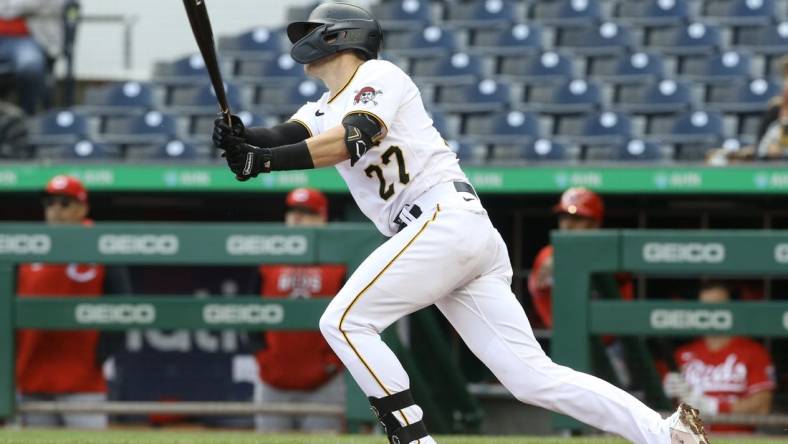 Sep 28, 2022; Pittsburgh, Pennsylvania, USA;  Pittsburgh Pirates second baseman Kevin Newman (27) hits a game winning single to defeat the Cincinnati Reds in ten innings at PNC Park. The Pirates won 4-3 in ten innings.  Mandatory Credit: Charles LeClaire-USA TODAY Sports