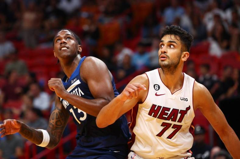 Oct 4, 2022; Miami, Florida, USA;  Miami Heat center Omer Yurtseven (77) and Minnesota Timberwolves forward Nathan Knight (13) fight for a rebound in the fourth quarter during preseason at FTX Arena. Mandatory Credit: Nathan Ray Seebeck-USA TODAY Sports