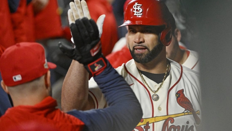 Oct 8, 2022; St. Louis, Missouri, USA; St. Louis Cardinals designated hitter Albert Pujols (5) is congratulated in the dugout following his single in the eighth inning against the Philadelphia Phillies during game two of the Wild Card series for the 2022 MLB Playoffs at Busch Stadium. Mandatory Credit: Jeff Curry-USA TODAY Sports