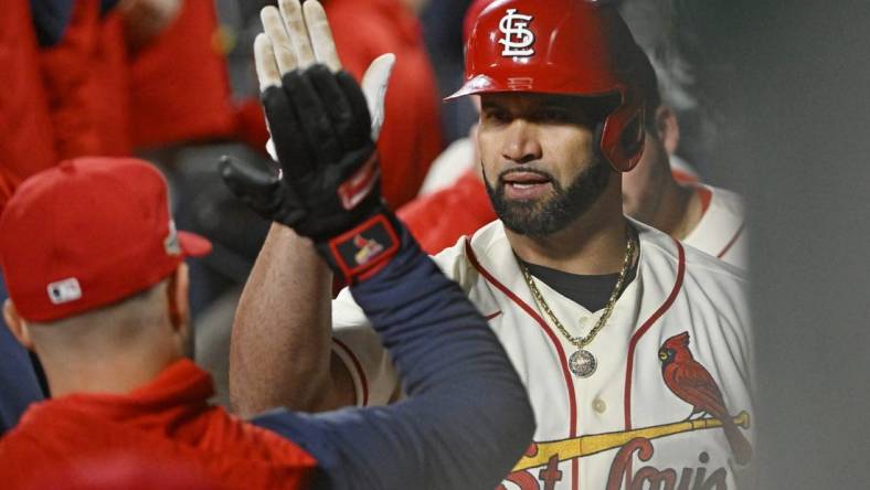 Oct 8, 2022; St. Louis, Missouri, USA; St. Louis Cardinals designated hitter Albert Pujols (5) is congratulated in the dugout following his single in the eighth inning against the Philadelphia Phillies during game two of the Wild Card series for the 2022 MLB Playoffs at Busch Stadium. Mandatory Credit: Jeff Curry-USA TODAY Sports