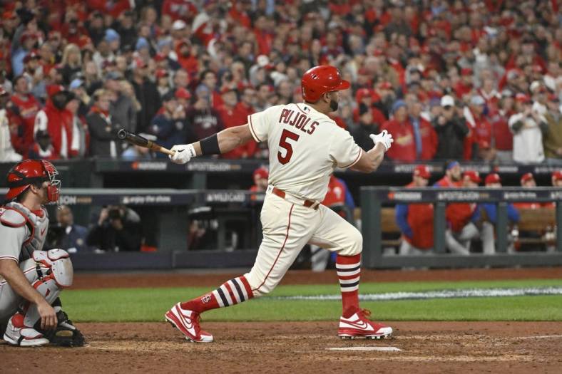 Oct 8, 2022; St. Louis, Missouri, USA; St. Louis Cardinals designated hitter Albert Pujols (5) hits a single in the eighth inning against the Philadelphia Phillies during game two of the Wild Card series for the 2022 MLB Playoffs at Busch Stadium. Mandatory Credit: Jeff Curry-USA TODAY Sports