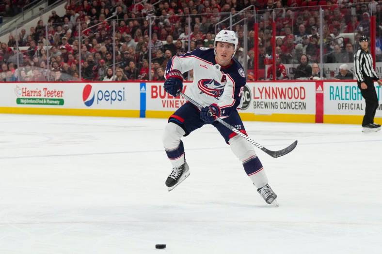 Oct 12, 2022; Raleigh, North Carolina, USA;  Columbus Blue Jackets defenseman Zach Werenski (8) passes the puck against the Carolina Hurricanes during the second period at PNC Arena. Mandatory Credit: James Guillory-USA TODAY Sports