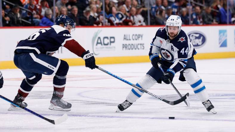 Oct 19, 2022; Denver, Colorado, USA; Winnipeg Jets defenseman Josh Morrissey (44) controls the puck as Colorado Avalanche right wing Mikko Rantanen (96) defends in the third period at Ball Arena. Mandatory Credit: Isaiah J. Downing-USA TODAY Sports