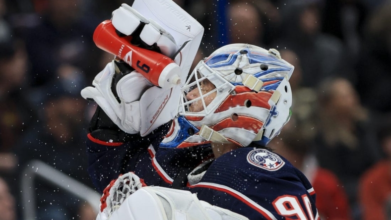 Oct 20, 2022; Columbus, Ohio, USA;  Columbus Blue Jackets goaltender Elvis Merzlikins (90) sprays his face with water during a stop in play against the Nashville Predators in the third period at Nationwide Arena. Mandatory Credit: Aaron Doster-USA TODAY Sports