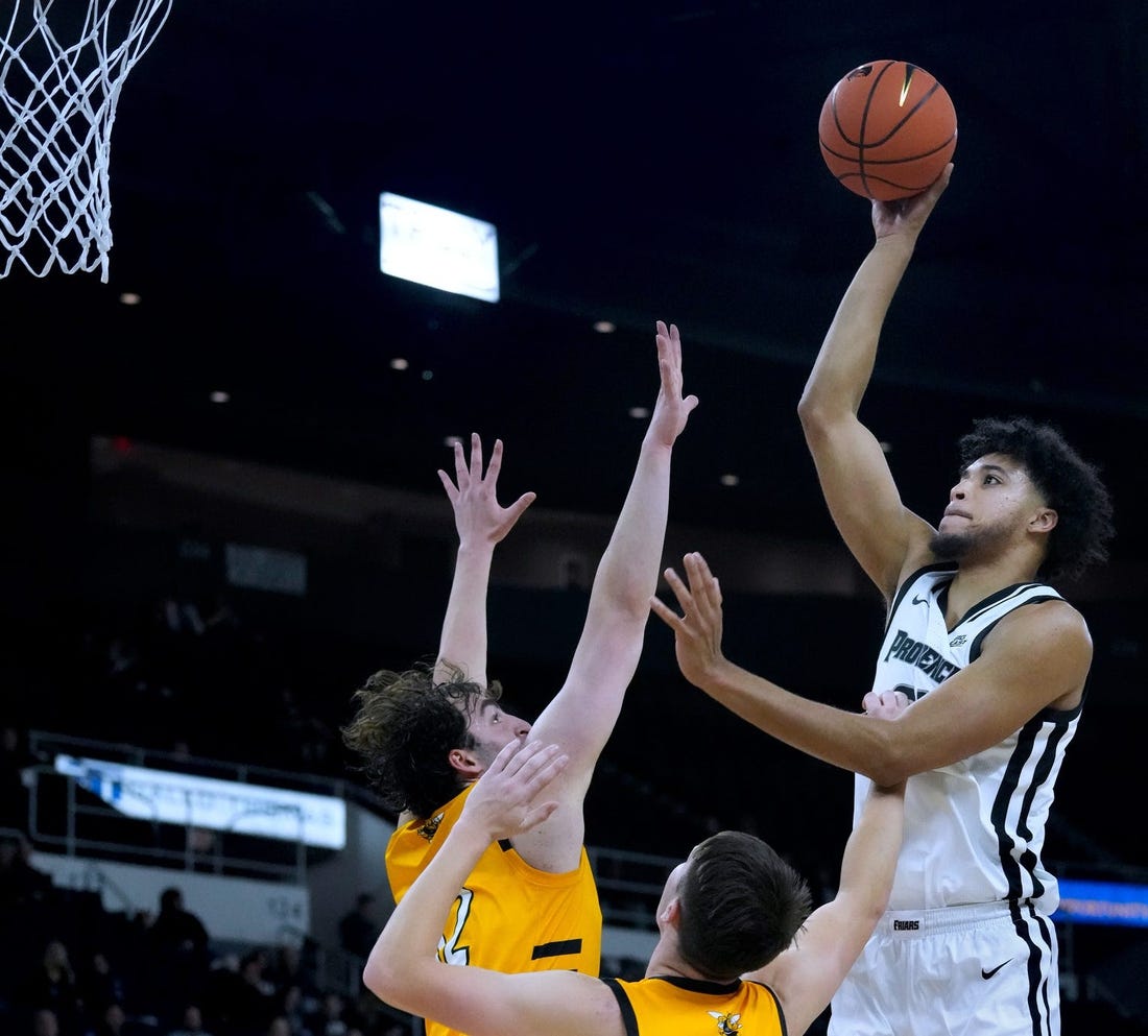 PC forward Clifton Moore shoots over Yellow Jacket defenders for a first half PC hoop.