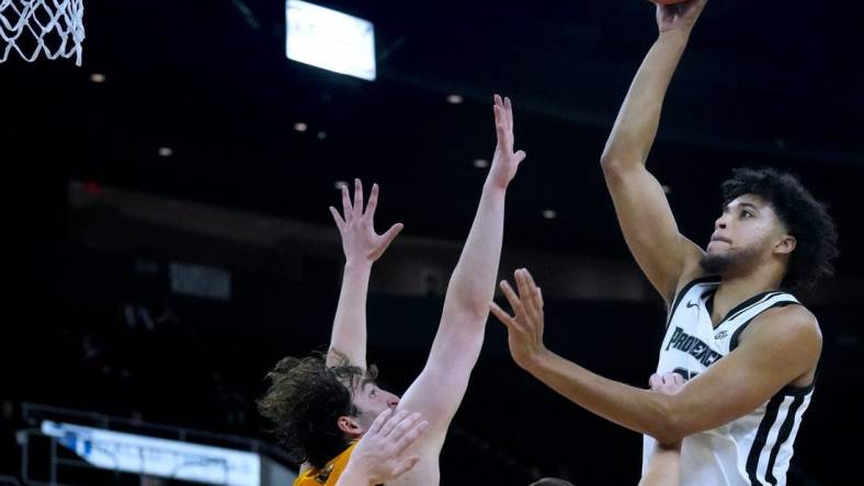 PC forward Clifton Moore shoots over Yellow Jacket defenders for a first half PC hoop.