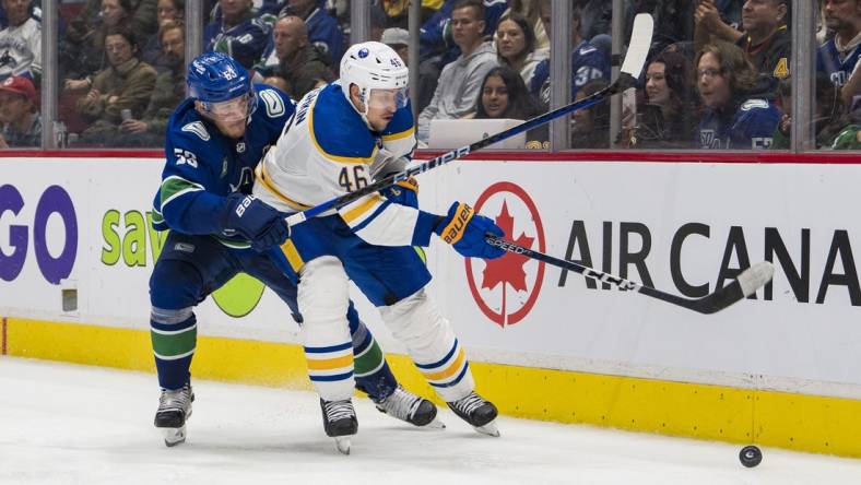 Oct 22, 2022; Vancouver, British Columbia, CAN; Vancouver Canucks forward Bo Horvat (53) checks Buffalo Sabres defenseman Ilya Lyubushkin (46) in the third period at Rogers Arena. Buffalo won 5-1. Mandatory Credit: Bob Frid-USA TODAY Sports