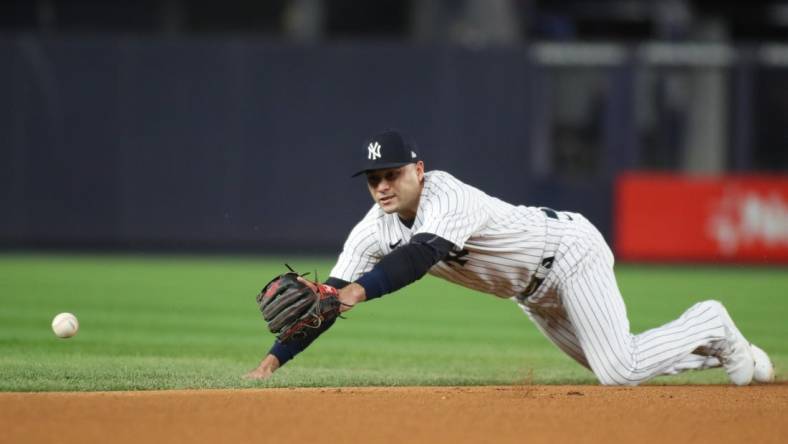 Oct 23, 2022; Bronx, New York, USA; New York Yankees shortstop Isiah Kiner-Falefa (12) dives for the ball in the first inning against the Houston Astros during game four of the ALCS for the 2022 MLB Playoffs at Yankee Stadium. Mandatory Credit: Wendell Cruz-USA TODAY Sports