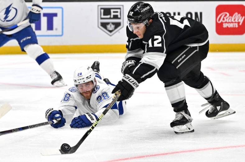 Oct 25, 2022; Los Angeles, California, USA;  Tampa Bay Lightning defenseman Ian Cole (28) defends Los Angeles Kings center Trevor Moore (12) as he takes a shot on goal in the second period at Crypto.com Arena. Mandatory Credit: Jayne Kamin-Oncea-USA TODAY Sports