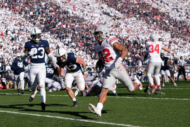 Oct 29, 2022; University Park, Pennsylvania, USA; Ohio State Buckeyes running back TreVeyon Henderson (32) runs for a 7-yard touchdown past Penn State Nittany Lions linebacker Tyler Elsdon (43) and linebacker Curtis Jacobs (23) during the fourth quarter of the NCAA Division I football game at Beaver Stadium. Mandatory Credit: Adam Cairns-The Columbus Dispatch

Ncaa Football Ohio State Buckeyes At Penn State Nittany Lions