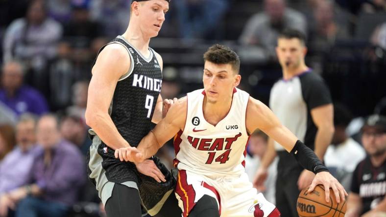 Oct 29, 2022; Sacramento, California, USA; Miami Heat guard Tyler Herro (14) dribbles the ball against Sacramento Kings guard Kevin Huerter (9) during the third quarter at Golden 1 Center. Mandatory Credit: Darren Yamashita-USA TODAY Sports