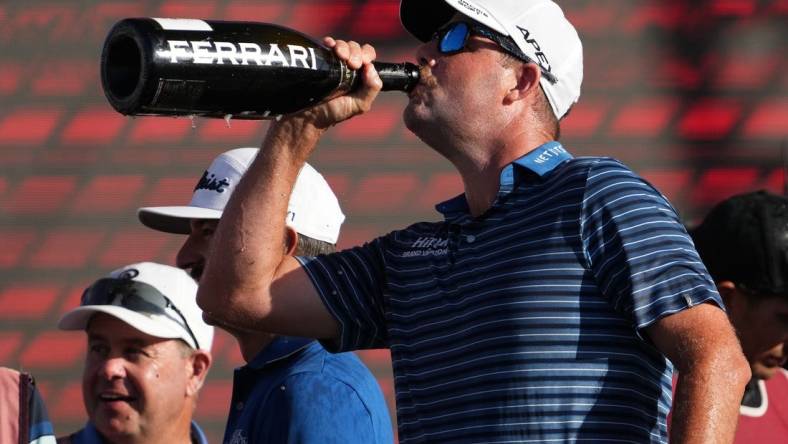 Oct 30, 2022; Miami, Florida, USA; Punch GC teammate Marc Leishman drinks champagne after his team finished second place in the team championship of the season finale of the LIV Golf series at Trump National Doral. Mandatory Credit: Jasen Vinlove-USA TODAY Sports