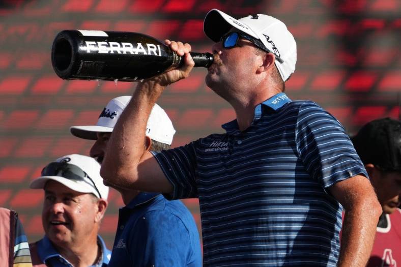 Oct 30, 2022; Miami, Florida, USA; Punch GC teammate Marc Leishman drinks champagne after his team finished second place in the team championship of the season finale of the LIV Golf series at Trump National Doral. Mandatory Credit: Jasen Vinlove-USA TODAY Sports