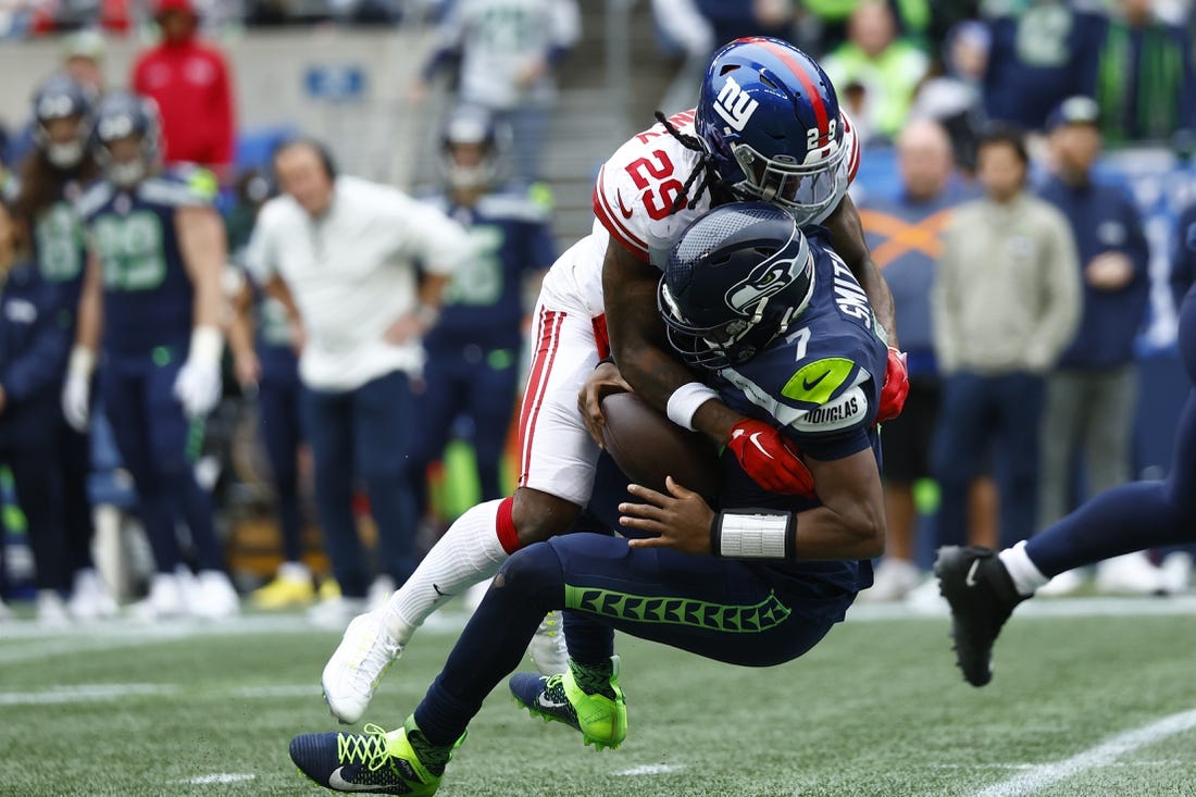 Oct 30, 2022; Seattle, Washington, USA; New York Giants safety Xavier McKinney (29) sacks Seattle Seahawks quarterback Geno Smith (7)  during the second quarter at Lumen Field. Mandatory Credit: Joe Nicholson-USA TODAY Sports