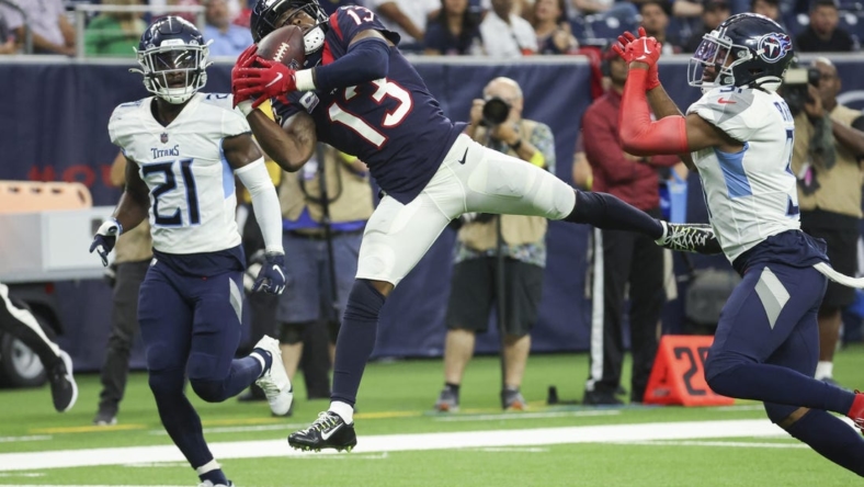Oct 30, 2022; Houston, Texas, USA; Houston Texans wide receiver Brandin Cooks (13) makes a reception during the fourth quarter as Tennessee Titans cornerback Roger McCreary (21) defends at NRG Stadium. Mandatory Credit: Troy Taormina-USA TODAY Sports