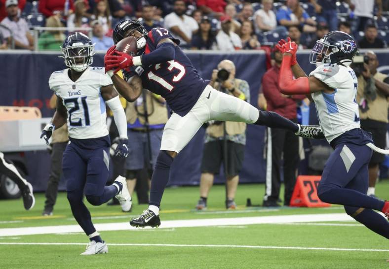 Oct 30, 2022; Houston, Texas, USA; Houston Texans wide receiver Brandin Cooks (13) makes a reception during the fourth quarter as Tennessee Titans cornerback Roger McCreary (21) defends at NRG Stadium. Mandatory Credit: Troy Taormina-USA TODAY Sports
